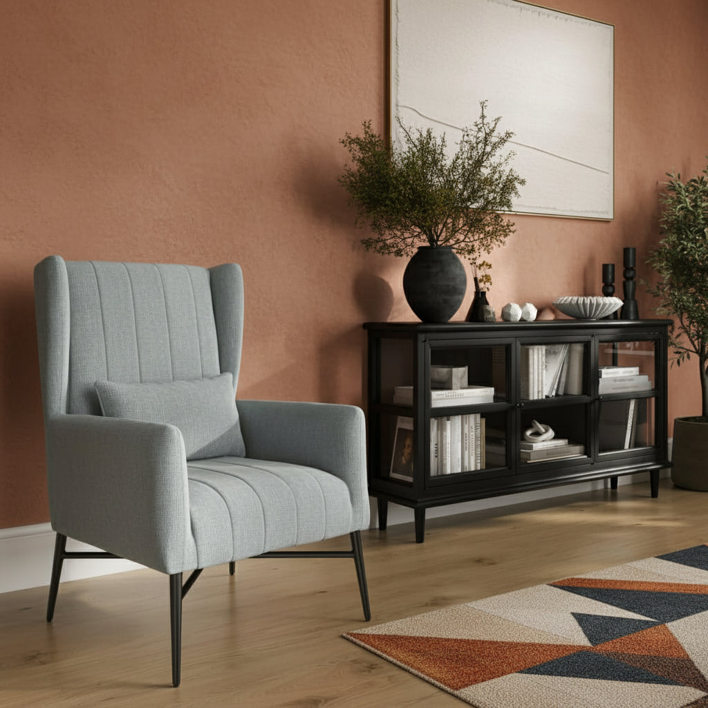 Grey armchair in a living room with a black console table and decorative items. Harry Christian Home Enya Armchair In Seafoam Tweed Lifestyle Shot