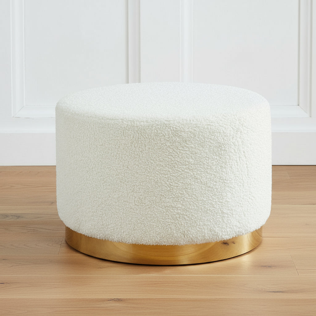 Harry Christian Home Large Teddy Bear Style White Pouffe / Footstool with golden base Round white upholstered ottoman with a gold base on a gray floor against a dark paneled wall.