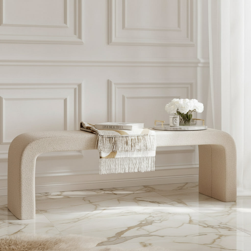Modern beige console table with decorative items against a white paneled wall. Harry Christian Home Moderno Bench In Light Buff with accessories lifestyle shot